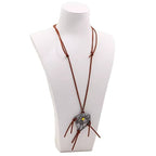 Weathered dreamcatcher necklace — detailed metal pendant.